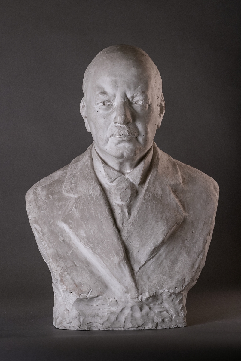 Byst, originalgips, av "Brukspatron Per Eriksson" av Ida Thoresen. Per Eriksson var anställd som disponent vid Hofors bruk 1890-1916 av familjen Wallenberg som ägde bruket. Han kallades allmänt för brukspatron, vilket egentligen är en titel på ägaren av ett bruk.