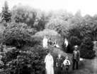 Alphems arboretum. Fotot taget på källarbacken nv om bostadshuset. Amanda och Frans Johan Gegerfeldt och barnen Astrid och Kalle. I bakgrunden fotografen Torsten Fält och systrarna Samuelsson från Trädgården, Floby.