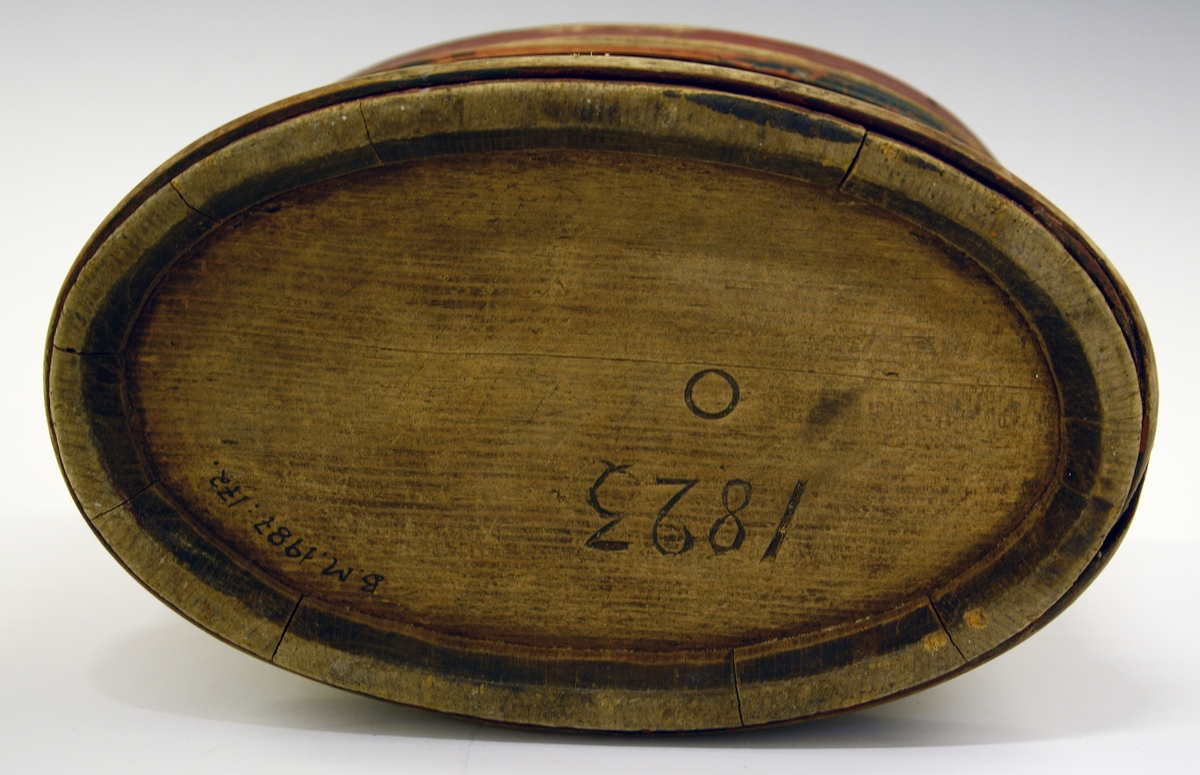 Eske (ask) med lokk. Lagget. Brunmalt med blå gjorder. Påskrevet "Ole Evendsen Brekka 1859". I bunnen er innskåret "1823" og "O".