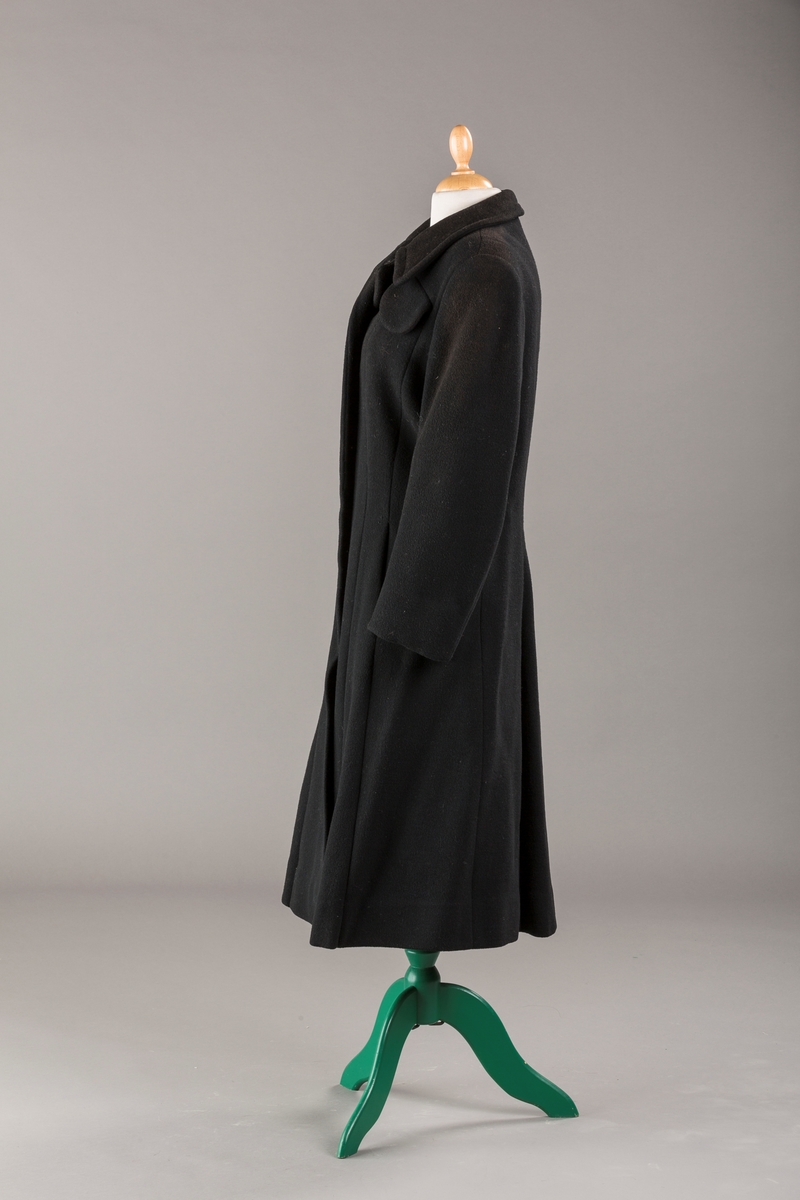 Innsvinget liv, pynteklaffer ved brystet foran. 
Stikklommer foran.
Skulderputer
Fire trukne knapper
Avrundet krage