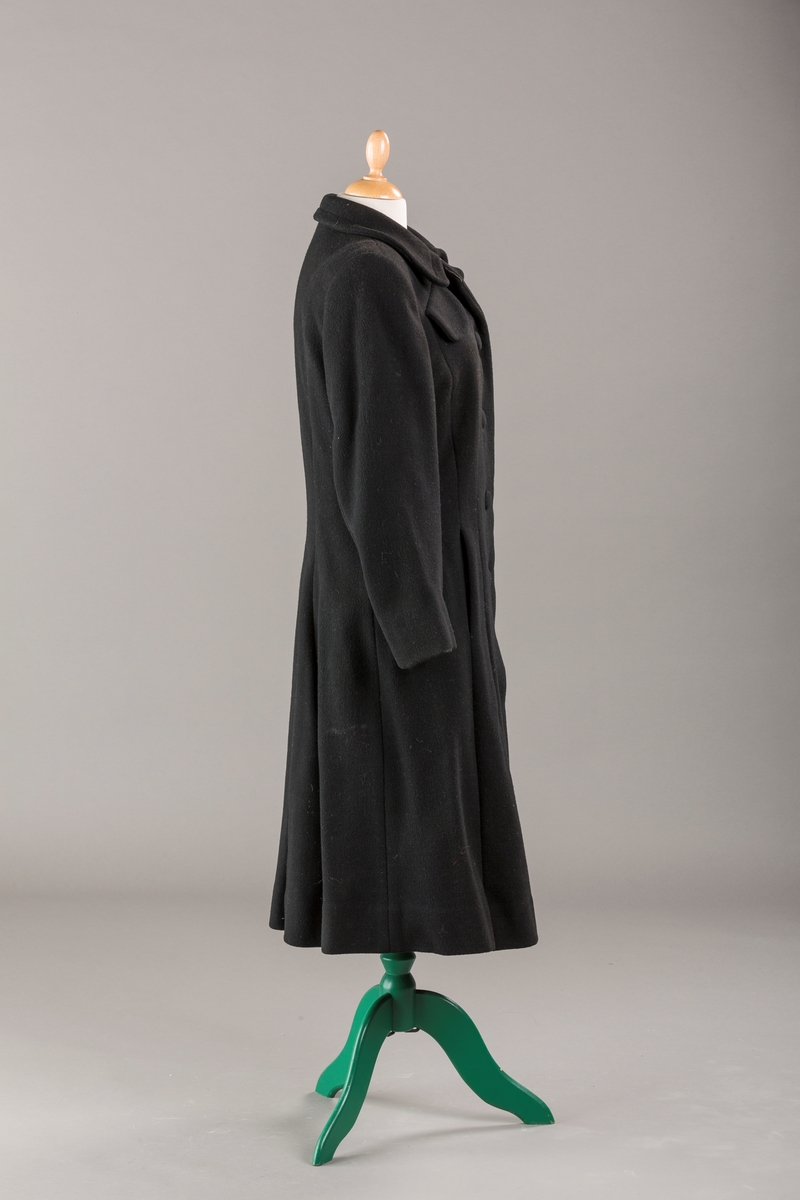 Innsvinget liv, pynteklaffer ved brystet foran. 
Stikklommer foran.
Skulderputer
Fire trukne knapper
Avrundet krage