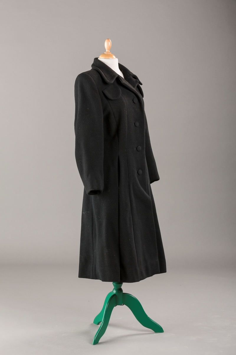 Innsvinget liv, pynteklaffer ved brystet foran. 
Stikklommer foran.
Skulderputer
Fire trukne knapper
Avrundet krage