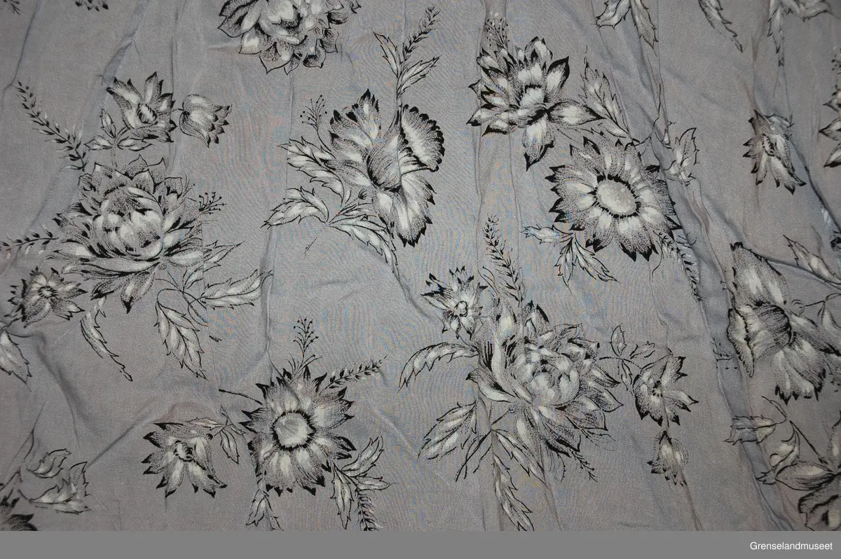 Grå viscose med trykt blomstermønster i sort og hvitt
helklipt
korte ermer
flat krage