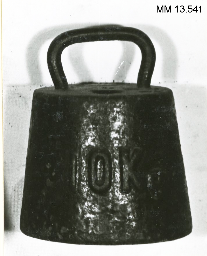 Vikt om 10 kg av järn. Märkt "10 K", "17   42" samt med kunglig krona. Svartmålad.