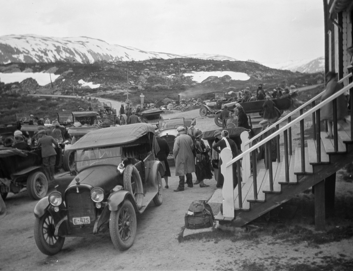 Oppland, Skjåk. Personer og flere biler utenfor Grotli Hotell. Foran trappen en Case E-475, som sto oppført som rutebil fra Otta-Geiranger- Stryn Interkommunale Bilselskap, Otta