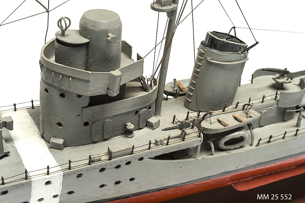 Tämligen grovt tillverkad fartygsmodell, huvudsaklingen gjord av trä. Fartyget är jagaren Mode som är målad grå över vattenlinjen och med röd bottenfärg. Klassiskt jagarskrov med upphöjd back. På fördäck står en kanon i öppen lavett och på akterdäck två likadana pjäser. Två luftvärnspjäser på en upphöjd brygga. En skorsten med svart topp. Slingekölar på båda sidor i rött. På bogen är siffrorna 29 målade. Alldeles för om bryggan och akter om den aktra pjäsen finns vita neutralitetsband målar över däck och ner längs skrovets sida till den svarta vattenlinjen. Fartyget har två propellrar. Bryggan är öppen. Modellen står på en fernissad platta av mörkt trä med hjälp av två profilerade små "pelare".