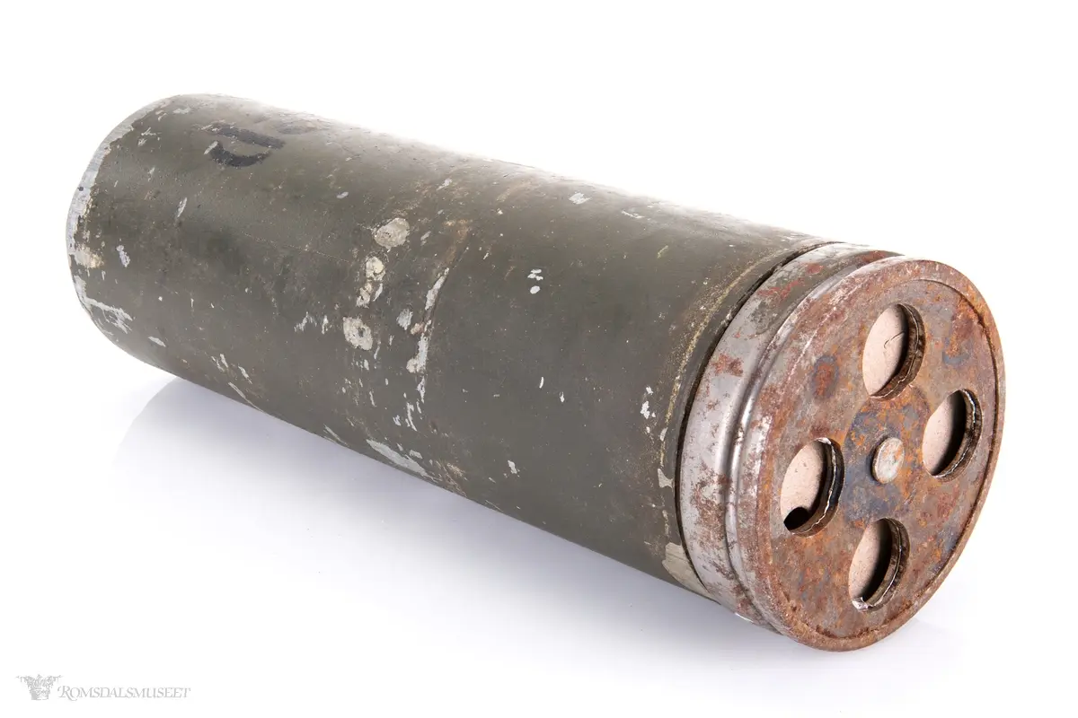 Ser ut til å være fronten på en røykgranat til 60 mm bombekaster. Sylinderformet med innmat foran og fire hull i nesen.