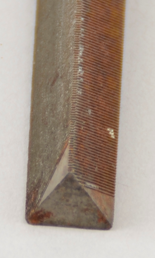 Form: Trekantfil.
Bruk: Fila vart nytta til å setja opp syler. Etter filinga vart bryne eller fint smergelpapir nytta for å finpusse.