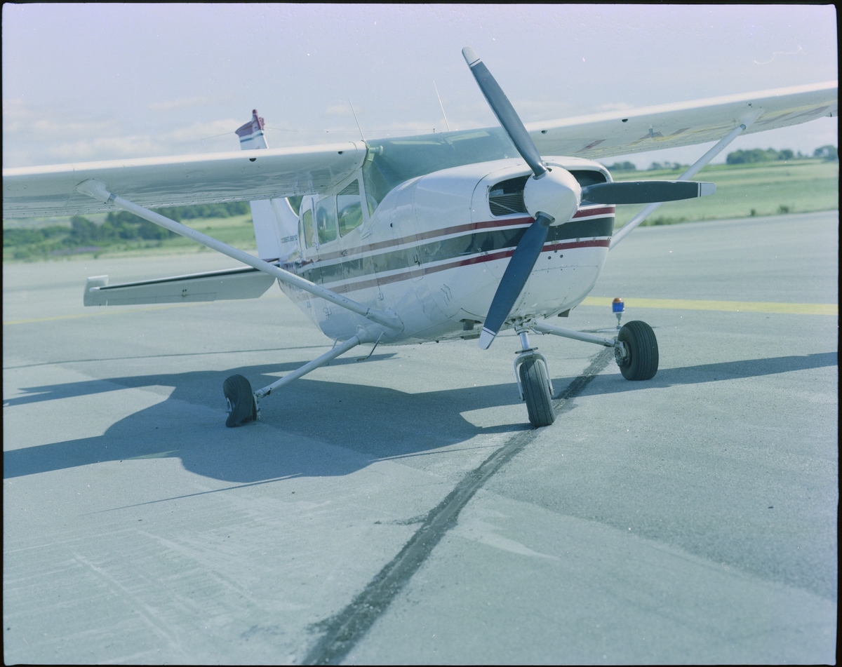To bilder av et fly med påskriften "LN-HAC" med punktert dekk, og fire flyfoto av et småfly med påskriften "LN-FAM" i lufta, alle fra "Coast Aero Center".