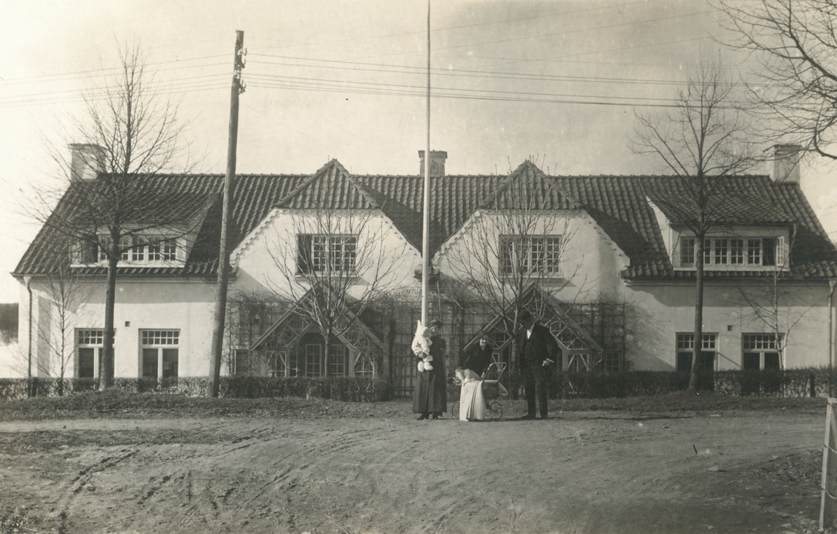 Makarna Axel Sundblad och Ebba Norman framför bostaden Villa Vesta i Kneippbaden. Bilden tagen en aprildag 1916. De bägge barnen är deras döttrar. I barnvagnen ligger dottern Brita på sin första dag utomhus med modern. I syster Esters famn dotter Maj. Hon avled emellertid i bukhinneinflammation redan till hösten.
