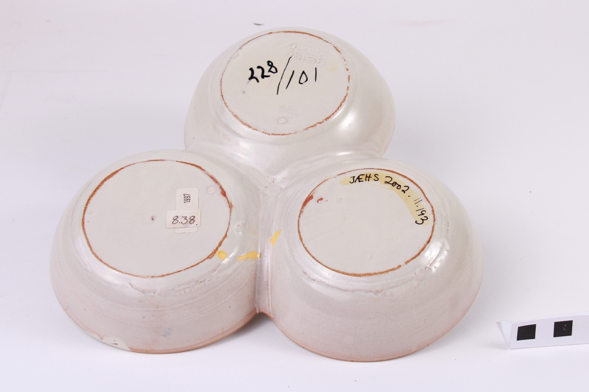 Kabaretfat i gråkvit farge med blomster i blått, gult, grønt og svart.