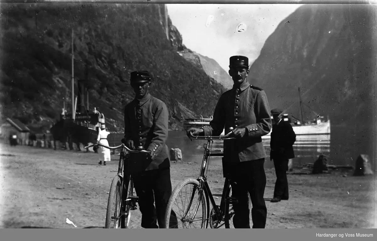 Odd Ystanes og ein til i militæruniform ved fjorden med kvar sin sykkel