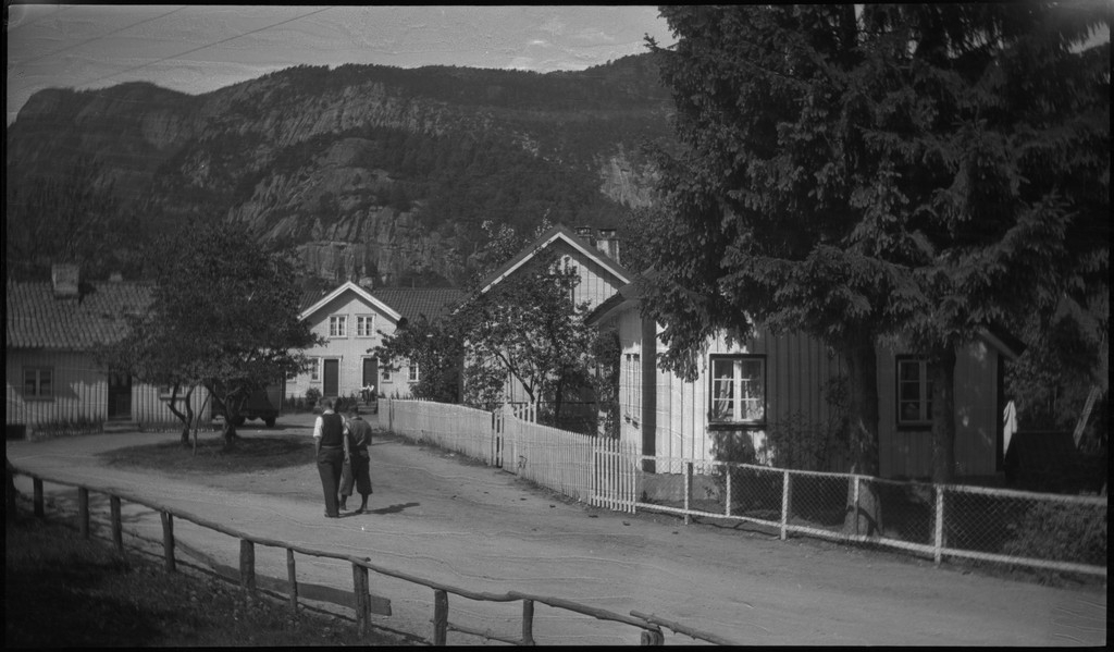 Biltur til Kvinesdal. Det er bilder tatt fra bilen fremover på veien og utover landskapet. Det er også bilder fra et tettsted ved en fjord. På bilde nr. 8 står det et hus med påskriften "HANSEN" på den andre siden av ei bru. På bilde nr. 17 sitter antageligvis Harald Bergsaker og Arne Johannessen på en stein i ei stri elv. Det er også flere bilder av en gruppe mennesker med en åpen buss. På bilde nr. 14 er L. A. B. Ådnesen til venstre.