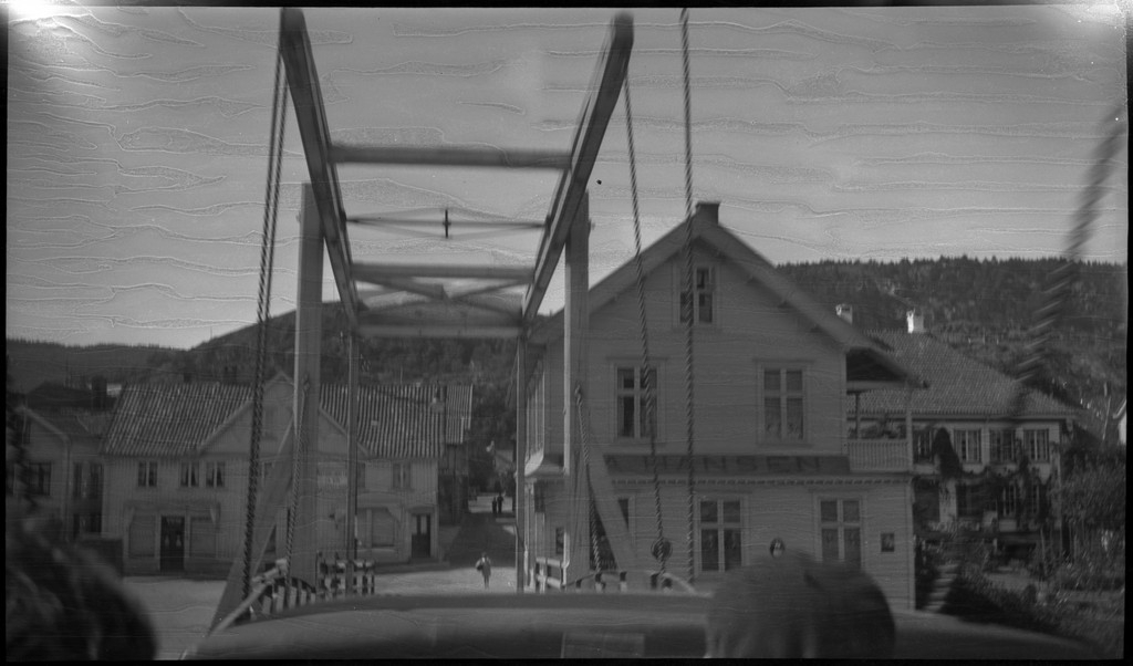Biltur til Kvinesdal. Det er bilder tatt fra bilen fremover på veien og utover landskapet. Det er også bilder fra et tettsted ved en fjord. På bilde nr. 8 står det et hus med påskriften "HANSEN" på den andre siden av ei bru. På bilde nr. 17 sitter antageligvis Harald Bergsaker og Arne Johannessen på en stein i ei stri elv. Det er også flere bilder av en gruppe mennesker med en åpen buss. På bilde nr. 14 er L. A. B. Ådnesen til venstre.