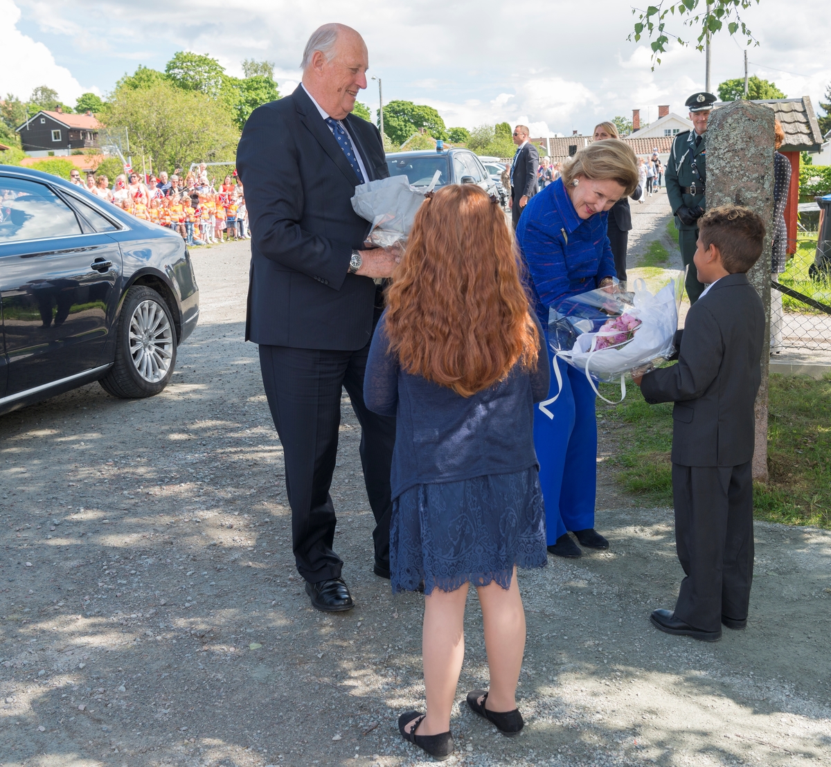 Deres Majesteter Kongen og Dronningen gjennomførte i perioden 11. til 14. juni 2017  en jubileumsreise med besøk til fylkene Hedmark og Oppland. Kongen og Dronningen avsluttet sin 80-års jubileumsreise i Innlandet med å besøke Kvinnemuseet og Kongsvinger. Bildet er tatt før omvisning på Kvinnemuseet. Barn overrekker blomster til  Kong Harald og Dronning Sonja. Nilja Noer-Johansen og Vincent Alexander Rubio, begge 9 år. Kongsvinger Museum. Kongebesøk. Blomsteroverrekkelse.