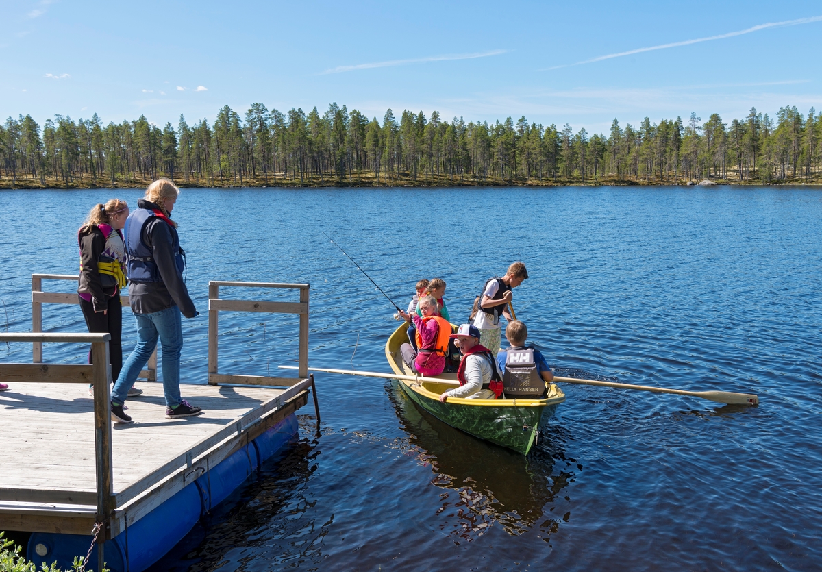 Bilder fra Blokkodden Villmarksmuseum ved Drevsjøen i Engerdal, Hedmark. Ungdom i robåt ved fiskebrygga. Roing. Båt. Skoleelever fra Engerdal barneskole og Sømodalen barneskole.