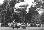 F6 Karlsborg. Fanjunkare Lidman, fallskärmsjägarskolan, fallskärmshoppar på Svenska Flaggans Dag. Landning på Molidens idrottsplan. Albumet är en del av en donation från Karl-Axel Hansson, Karlsborg. Förteckning över hela donationen finns i albumet samt som Word-dokument.