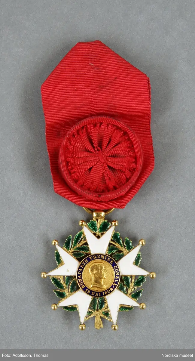 Huvudliggaren:
"a-h Ordenstecken, en samling som tillhört generalen Johan August Hazelius, 
a:1-3) Nordstjärneordens kors och kraschan i etui,
b:1-2) Svärdsordens kors och kraschan,
c:1-3) S:t Olafsordens kors och kraschan i etui,
d:1-3) Dannebrogsordens kors och kraschan i etui,
e) Hederslegionen,
f:1-2) Isabellaorden,
g:1-2) Österr. Järnkronorden,
h:1-2) Medalj i brons, 
10 visitkort.
Gåva enl. test.förordn. [från] fil. dr. A. Hazelius, Stockholm."
