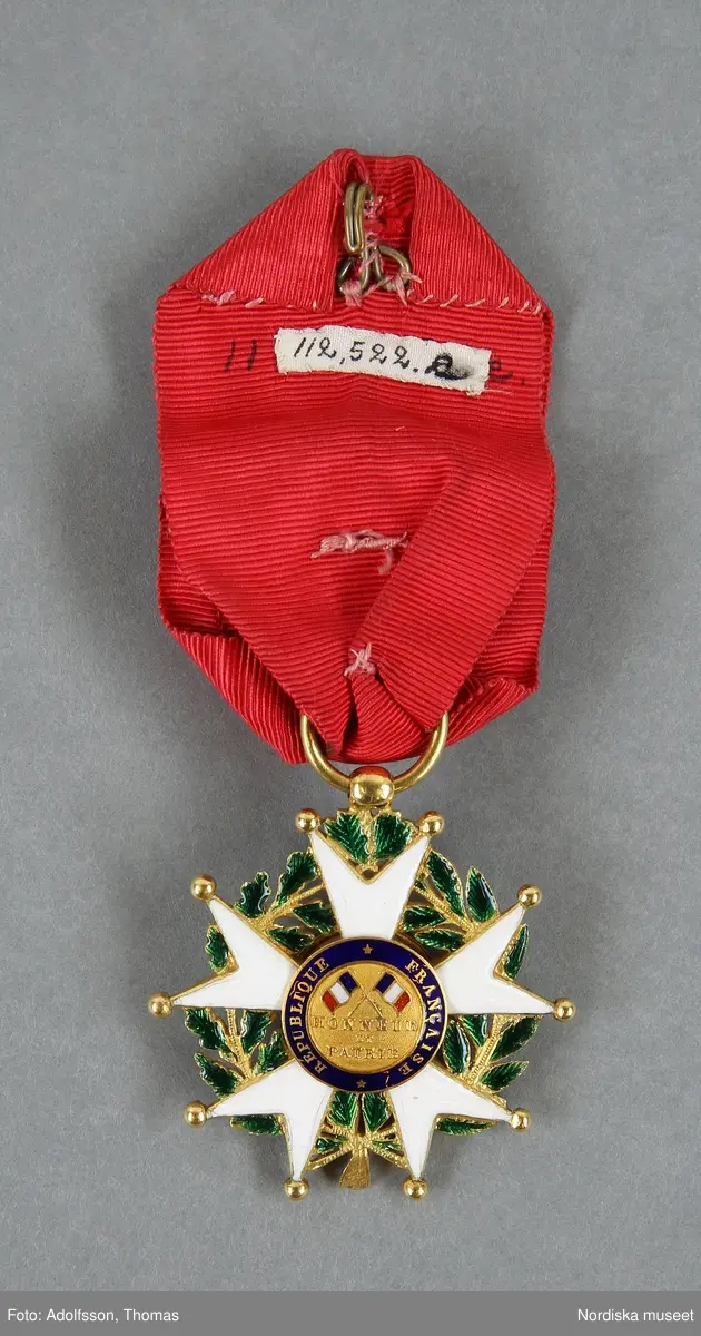 Huvudliggaren:
"a-h Ordenstecken, en samling som tillhört generalen Johan August Hazelius, 
a:1-3) Nordstjärneordens kors och kraschan i etui,
b:1-2) Svärdsordens kors och kraschan,
c:1-3) S:t Olafsordens kors och kraschan i etui,
d:1-3) Dannebrogsordens kors och kraschan i etui,
e) Hederslegionen,
f:1-2) Isabellaorden,
g:1-2) Österr. Järnkronorden,
h:1-2) Medalj i brons, 
10 visitkort.
Gåva enl. test.förordn. [från] fil. dr. A. Hazelius, Stockholm."