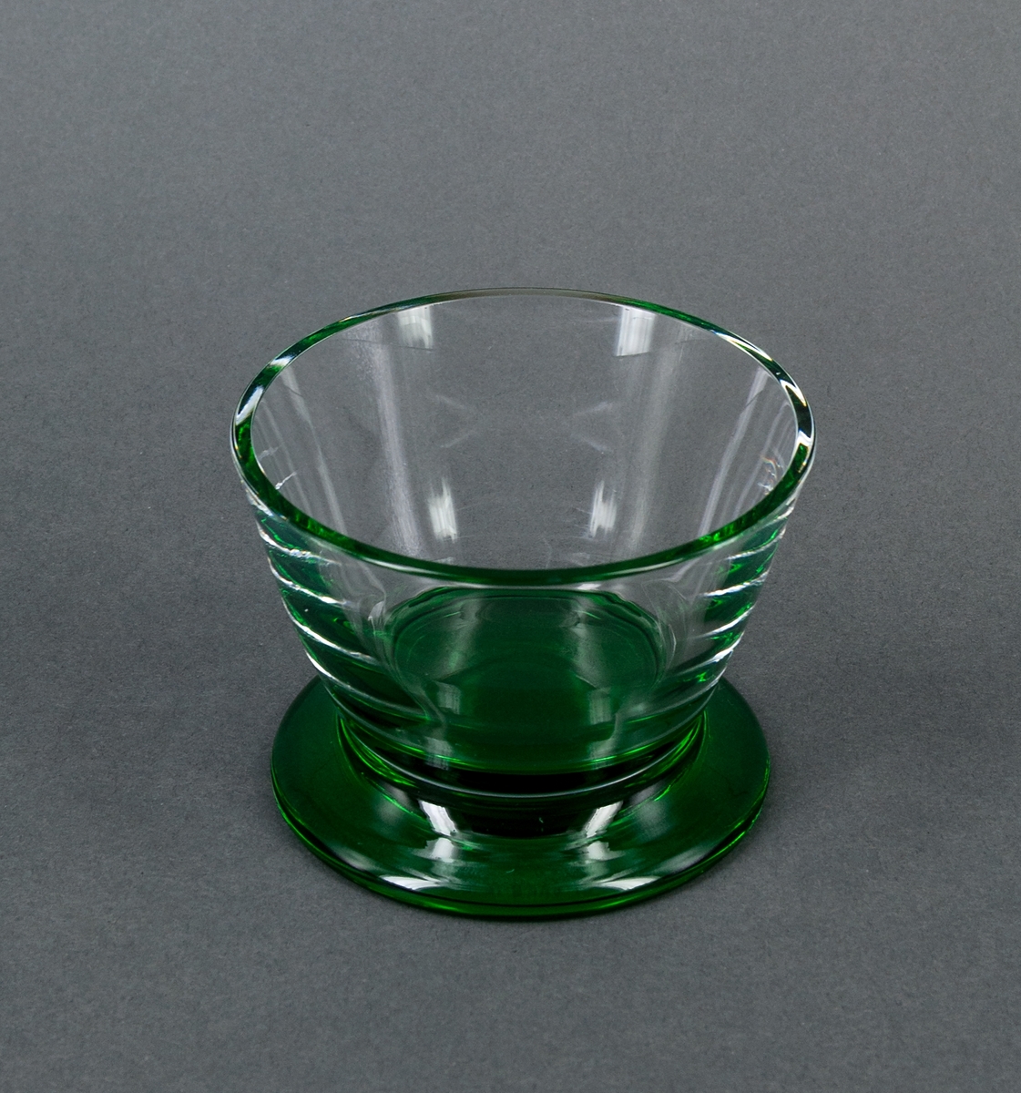 Sockerskålar, 2 st. Raka, utåtlutande sidor i ofärgat glas på låg, utkragad fot i grönt glas. Design Gunnar Cyrén för Orrefors Glasbruk.