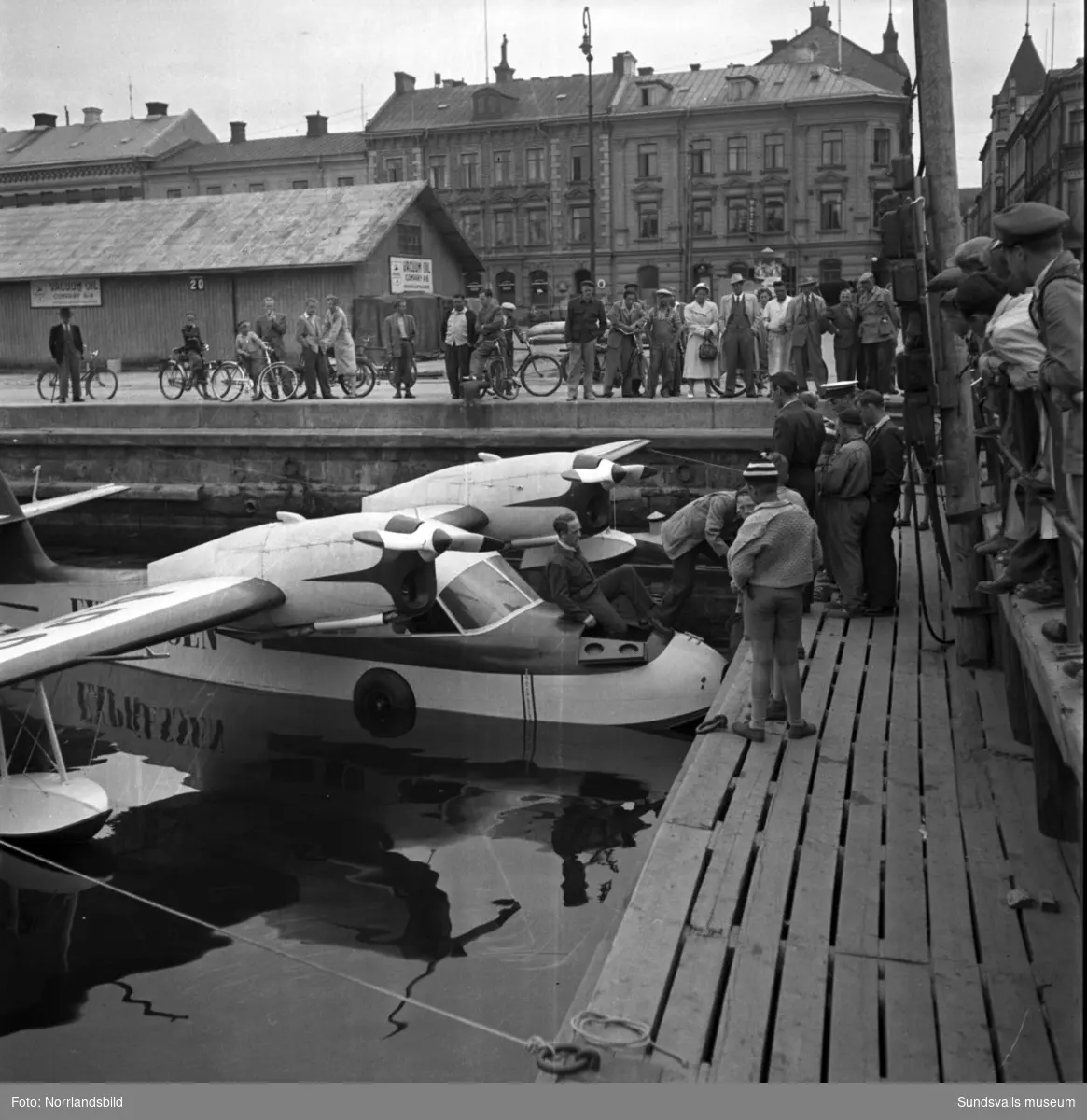 Många intresserade åskådare då Expressens tidningsplan på pontoner ligger förtöjd i hamnbassängen vid Tullgatan. Även bilder på planet ute vid Midlanda.