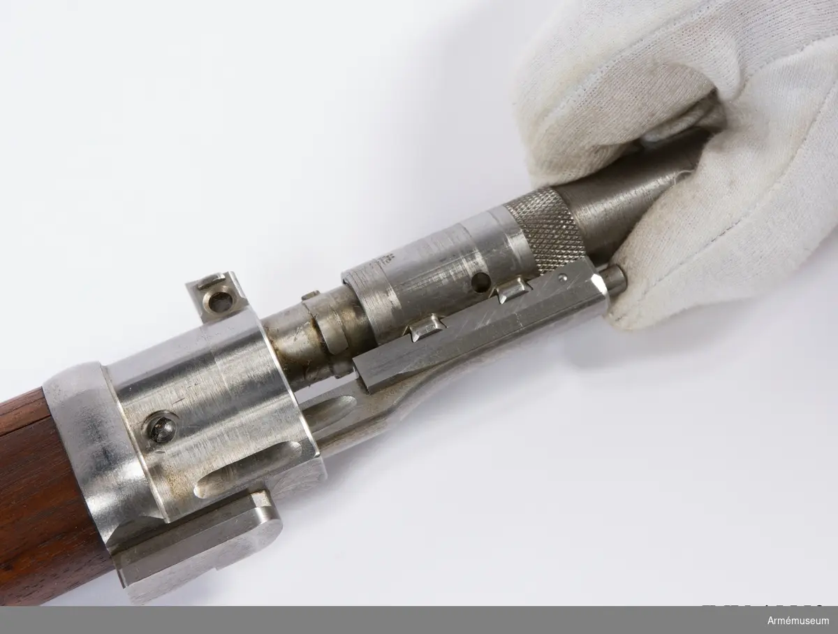 Försöksmodell med plats för 6 patroner i magasinet.

Enligt kinesiska gästers tolkning står på pipan "Arméns vapen- tillverknings verkstad i Hanyang"./1984-12-17 EW.

På baksidan av bilagan står antecknat med blyerts: "Uppfinnare: Liu Tsching En, generalmajor i Kinesiska armén,  Hanyang arsenal. Gevärsfaktori för tillverkning av 100 gevär om dagen med alla  tillhörande maskiner etc. tillverkades 1914-17 av Pratt &  Whitney Machine Co, Hartford, Conn. Ingeniör A.E. Larsson, Edeskvarna, Lyckåsgård. Geväret hopsatt av provdelar direkt från maskinerna." 

I kolven rengöringsverktyg.

Geväret isärplockat och ihopsatt 2018-01-12 på Armémuseum i studiesyfte.