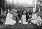 Ruben och Christiane Liljefors med barn och vänner har kaffepaus ute på gräsmattan på gården, sannolikt Svensgården, Dalarna