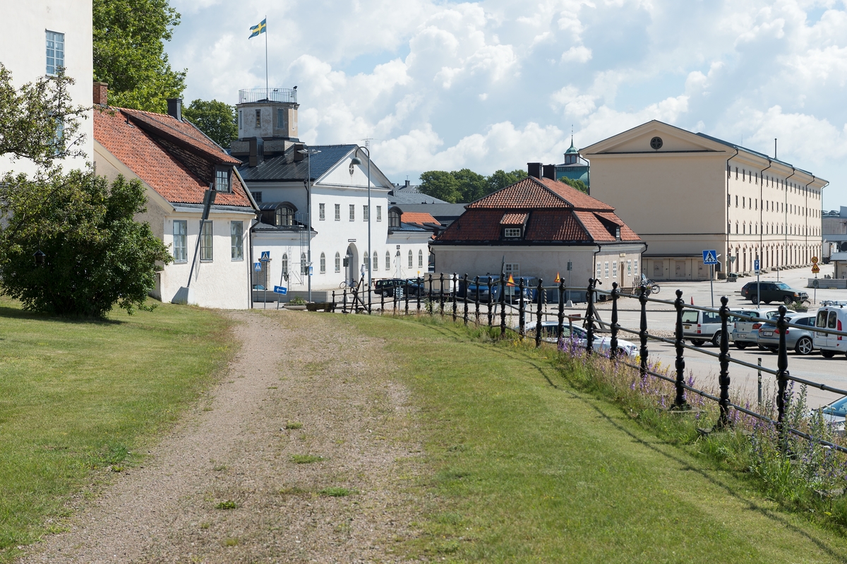 Fotodokumentation av byggnader på Marinbasen i Karlskrona. Längst till vänster syns Mönstersalsbyggnadens sydostra hörna. Näst i bild: Ekipagekontoret. Gamla högvakten. Före detta spruthuset. Längst till vänster i bild: "Silverhuset" som fick sitt namn sedan kungen frågat om huset var byggt i silver istället för sten, då kostnaderna var så höga till följd av dyra och de tidskrävande grundläggningsarbetena. Det s k silverhuset/Ivnetariekammare 1 uppfördes för förvaring av materiel från tolv linjeskepp. På bottenplan torkades och förvarades trossarna och på våningarna ovanför förvarades materiel som tåg och segel.