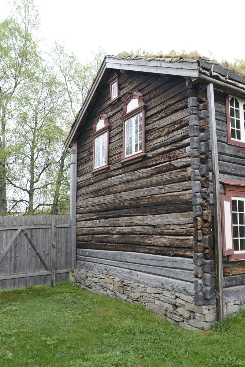 Bergmannsbolig av tømmer. Kledd med tømmermannspanel på gatefasaden. Taket er tekt med never og torv. Fasadeutstyret mot det offentlige rom holder en veldig høy standard. Bygningen er satt sammen av flere (to) eldre bolighus. Den tverrstilte midtarken er sekundært plassert oppå de sammenstilte bygningskroppene. Boligen fra Aspåsgården er sannsynligvis påbegynt  tidlig på 1700-tallet. Senere utvidet og mye forandret. Blant annet er det påbygd to omfar i hele 2. etg. og det er også satt inn større vinduskarmer. Trolig er dette skjedd i siste del av 1800-tallet. Det er gjenbrukt bygningselementer fra et sosialt høyere sjikt. Bygningen har to rom med fyllingspanelte vegger. - Et  rom i 2. etg. og et i midtarken. Disse to rommene har fått sine nytilvirkede veggpaneler etter at de har fått nåværende romhøyde og etter at det er satt inn større vinduskarmer. Bygningen er endret helt inn mot 1900-tallet.  Pløyd panel, brukt i bislag mot bakgården, representerer et siste trinn i Rørosbebyggelsens utviklingshistorie. Sto på Flanderborg, Røros. Gjenreist på Sverresborg 1917. I forbindelse med oppføringa på museet har bygningen vært gjenstand for omfattende tilbakeføringsforsøk, med blant annet ens vindusrammer for hver etasje. Ikke noe av det gamle panelet på gatefasaden er gjenbrukt. Nytt panel har også fått en annen utbredelse og underdeling enn tidligere. På Røros var bl. a. også grundmuren dekt av panel. Alt tømmermannspanel er nytt fra 1917. Dagens utseende er eksteriørmessig utvilsomt museumsskapt. Endringene, som er gjennomført på museet, har bidratt til klart å svekke et veldig godt eksempel på folkelig, lokal byggeskikk. 