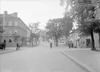 Motiv från Bispmotalagatan i Motala 1940. För orienteringens skull passerar ynglingen på cykel  Platensgatan.