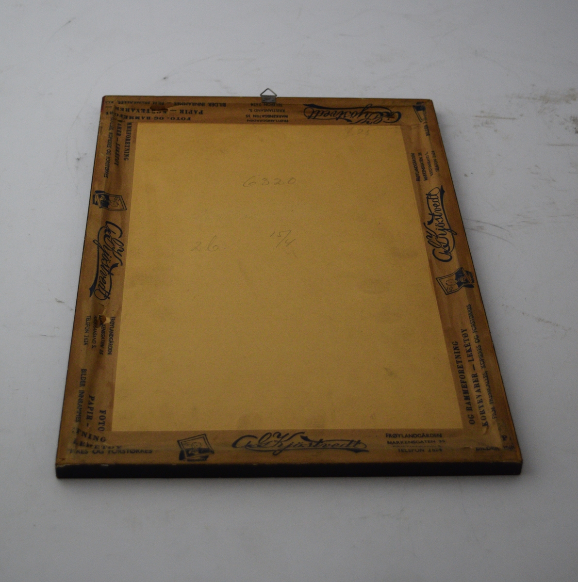 To skytevåpen i kryss med en blink over, sentralt oppe. Bladranke som ramme rundt skriften med en sløyfe på midten nederst.