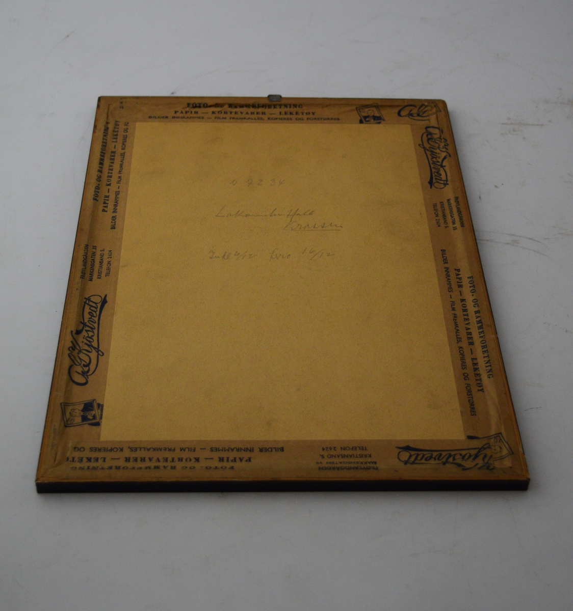 To skytevåpen i kryss med en blink over, sentralt oppe. Bladranke som ramme rundt skriften med en sløyfe på midten nederst.