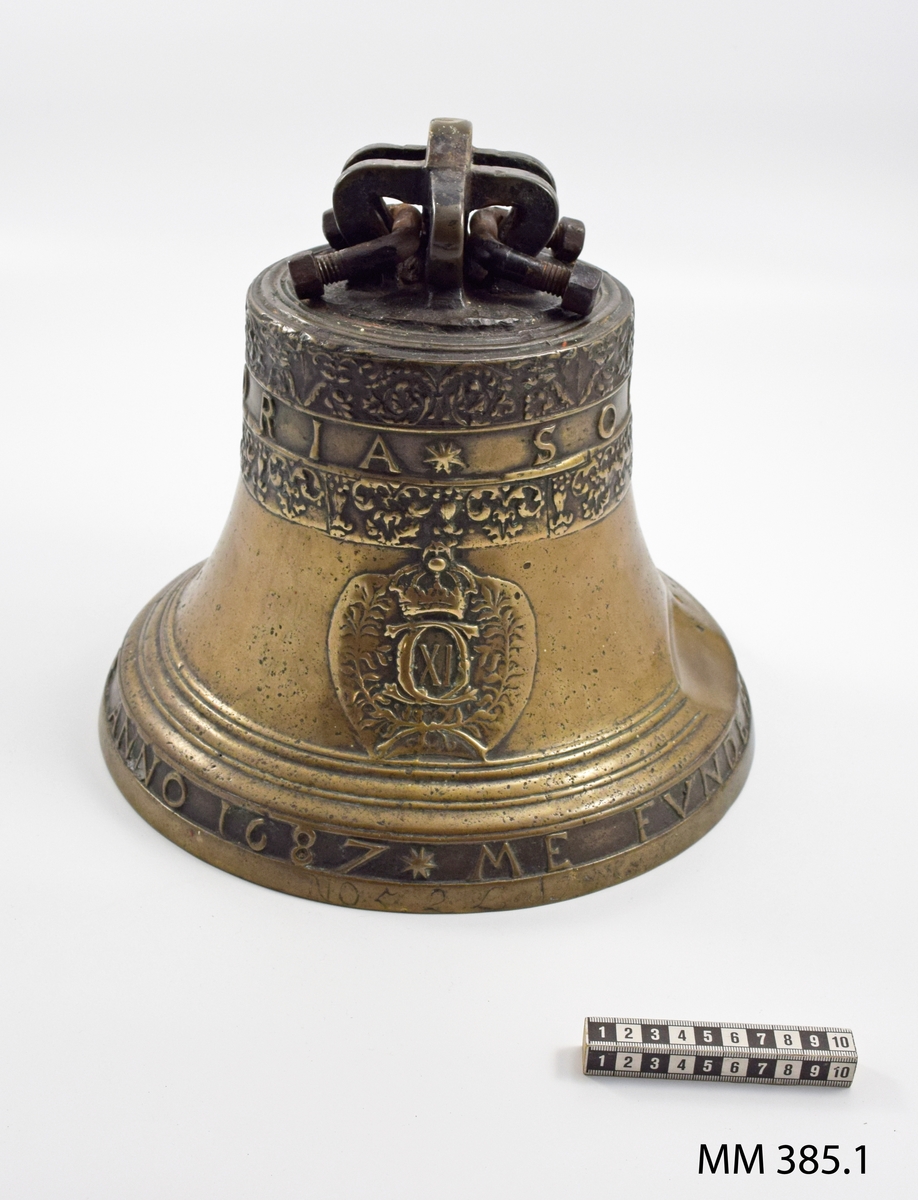 Skeppsklocka, av metall, gjuten år 1687 och försedd medföljande inskription,
upptill: "SOLI   DEO  GLORIA". och nedtill: "ME  FUNDEBAT  HOLMIAE  MICHEL  BADER  ANNO  1687". Mitt å ena sidan Carl XI:s namnchiffer under kunglig krona. Enligt anteckning har klockan senast tillhört briggen Gladan. Tillkom år 1905.