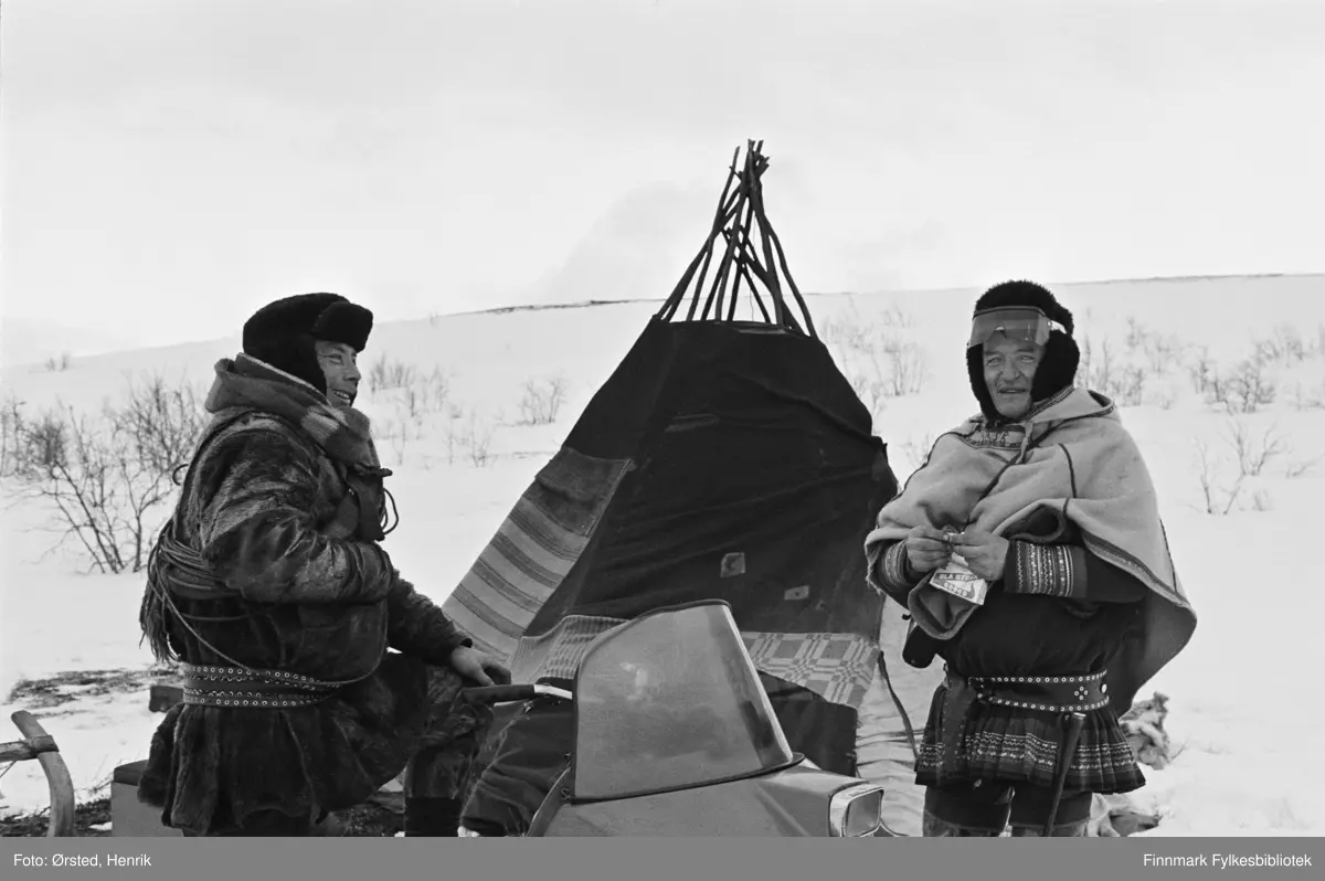På bildet sees Josef J.M. Sara som prater med postfører Mathis Mathisen Buljo, "Post-Mathis" ute på Finnmarksvidda. Josef J.M. Sara sitter på skuteren og Post-Mathis står og ruller Petterøs tobakk mens han slår av en prat med Josef. I bakgrunnen sees en lavvo. 

Fotograf Henrik Ørsteds bilder er tatt langs den 30 mil lange postruta som strakk seg fra Mieronjavre poståpneri til Náhpolsáiva, videre til Bavtajohka, innover til øvre Anárjohka nasjonalpark som grenser til Finland – og ruta dekket nærmere 30 reindriftsenheter. Ørsted fulgte «Post-Mathis», Mathis Mathisen Buljo som dekket et imponerende område med omtrent 30.000 dyr og reingjetere som stadig var ute i terrenget og i forflytning. Dette var landets lengste postrute og postlevering under krevende vær- og føreforhold var beregnet til 2 dager. Bildene gir et unikt innblikk i samisk reindriftskultur på 1970-tallet. Fotograf Henrik Ørsted har donert ca. 1800 negativer og lysbilder til Finnmark Fylkesbibliotek i 2010.