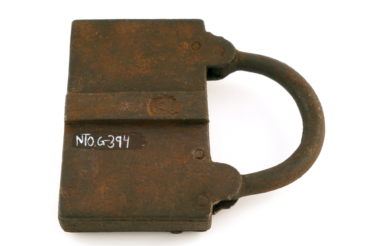 Hengelås av jern. Firkantet med svingbart lokk over nøkkelhull. I tillegg er det et ekstra lokk over låsbøylens ende.
Enden av låsbøylen hadde et hull, som gjorde at låsen kunne forsegles, ved at det ble trukket en forseglingstråd
gjennom låsbøylens ende og deretter plombert med en bly - eller lakk-plombe. Lokket beskyttet så forseglingen.