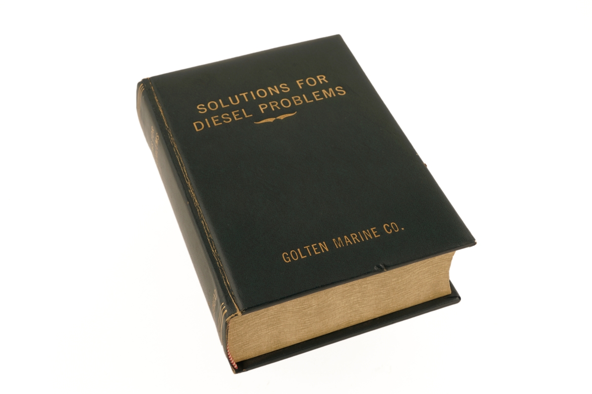 Bok i mørk grønt skinn. Det som skulle være boksider, er treverk. Dette er uthult for å romme sigaretter.