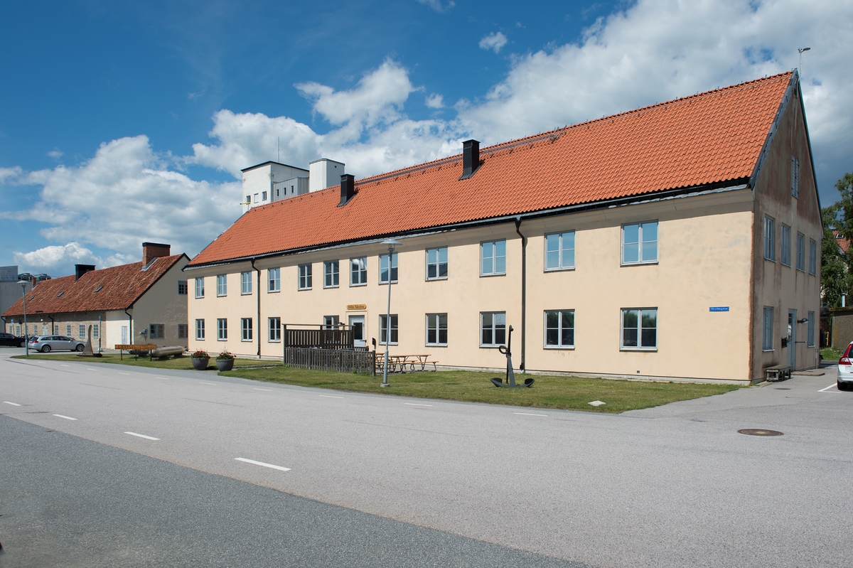 Byggnad i en våning med inredd vind. Fasad i kalksten och tegel och brant sadeltak.