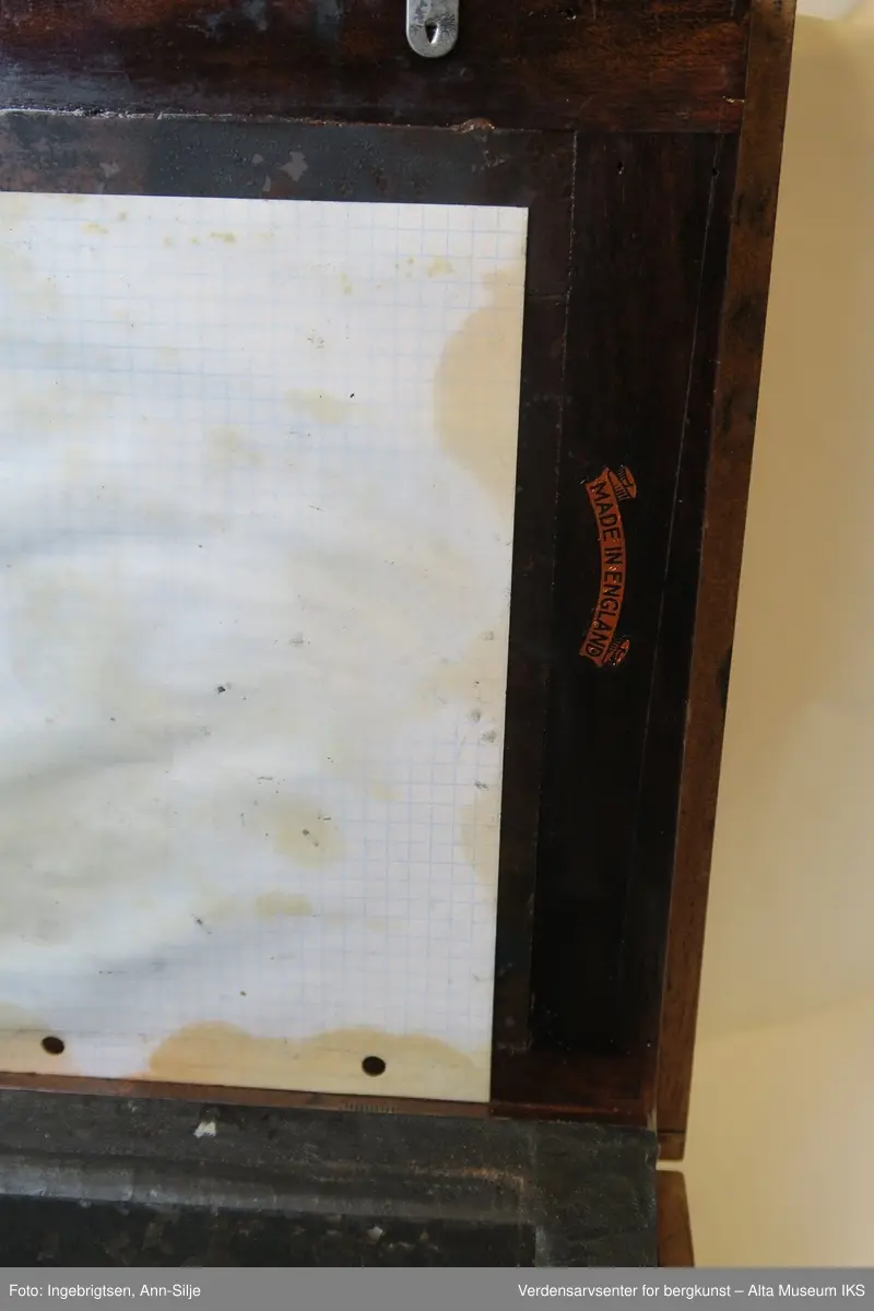 Trekoffert med et lite metallhåndtak. Inn i kofferten er det sverterull, plater, et rutet ark og en sjablong med motiv av en blomst. Både platene og det inngraverte stykket har et lag av inntørket sverte.