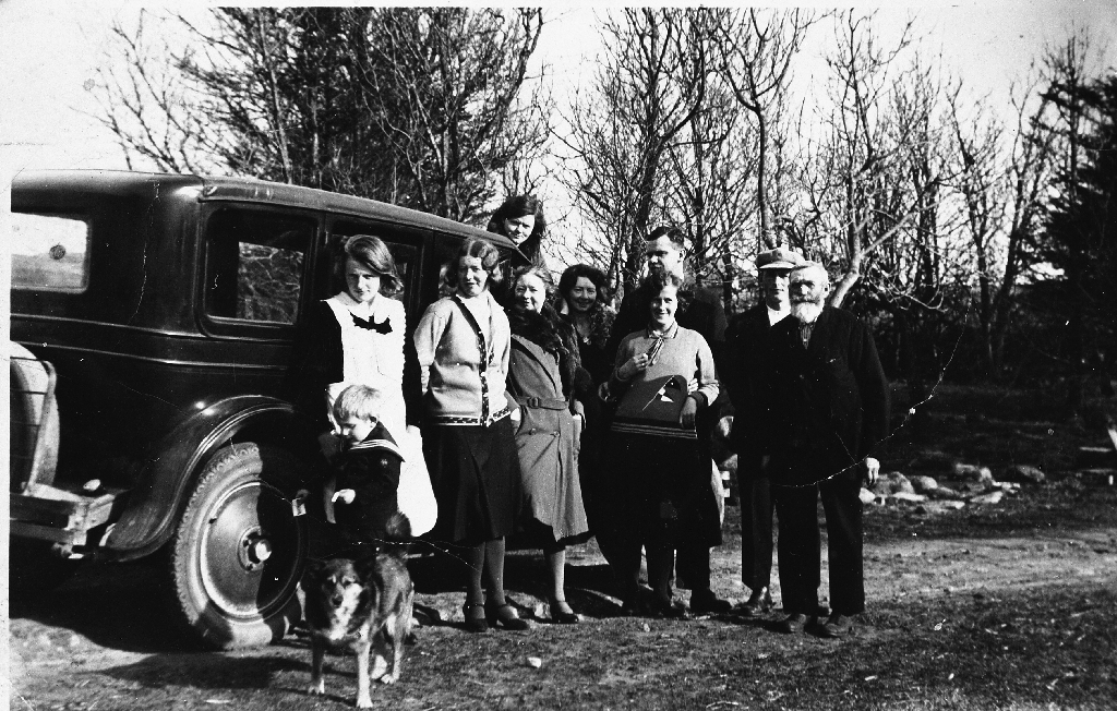 Gruppebilete med bil.
F.v. : Einar Herigstad (22.12.1928 - 4.2.2012) budde i Halden, Nora  Marie Herigstad f. Bruseli (9.7.1907 - 3.4.2000), Olga Line, Josefine Line, Ukjent, Borghild Abeland (framme), Olaf Abeland (10.6.1900 - 19.12.1973) (bak), Johannes Herigstad (3.7.1906 - 7.2.1960), og Erik Herigstad (23.11.1864 - 16.9.1940). Margit Line oppå bilen. Hund en heitte "Freia".