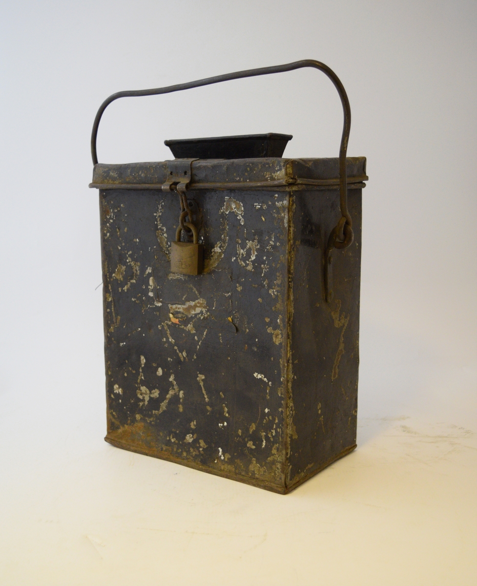 Firkantet kasse med lokk festet med hengsle og hengelås. Smal rektangulær åpning midt i lokket med trakt. Hank festet på sidene.