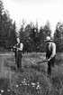 Henrik Mattson-Bäckström med sonen Fridolf, Snårberg. Fotot från 1920-talet. Henrik var kyrkovaktmästare i Nyskoga i många år. Platsen är troligen den del av kyrkogården som inte är planterad. Bäckström bodde i Skomakarns i Snårberg. Han kunde inte cykla, utan gick 6 km till kyrkan. Vintertid gick han till kyrkan redan på lördagen och började elda, låg sedan över på en bänk och fick på så vis varmt i kyrkan till högmässan kl. 11.00.