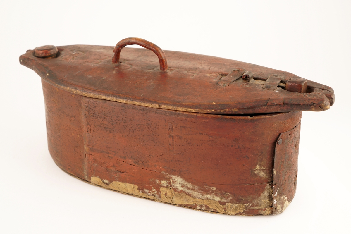 Nistelaup av rødmalt tre. Oval med svingbart lokk, festet i den ene enden med en trenagle. Hank og lås på lokket.