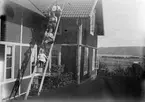 Ruben och Christiane Liljefors barn, Alf, Roland, Ingemar och Marit sitter på stegen vid bostadshus, sannolikt i Sverige