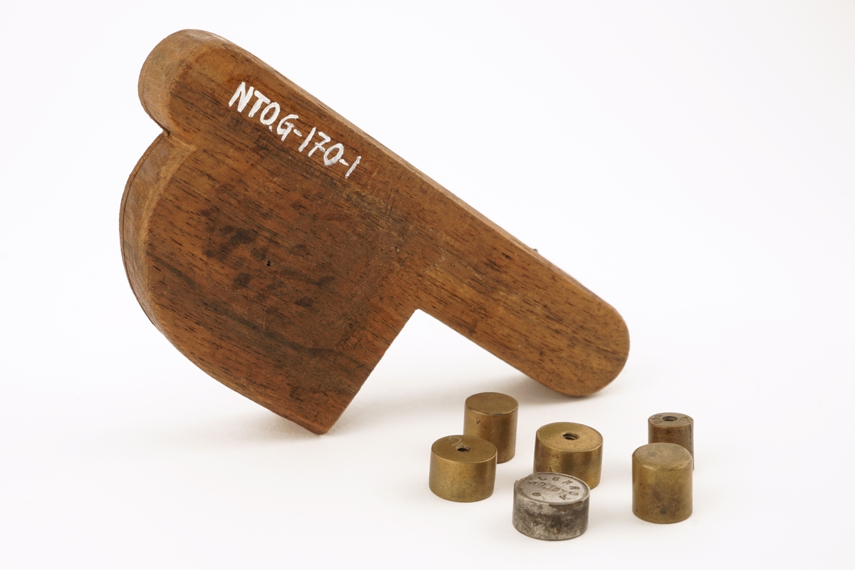 1 tre - eske inneholdende 6 stk. lodd. På oversiden av esken finnes et utydelig merke.
Esken er P - formet.