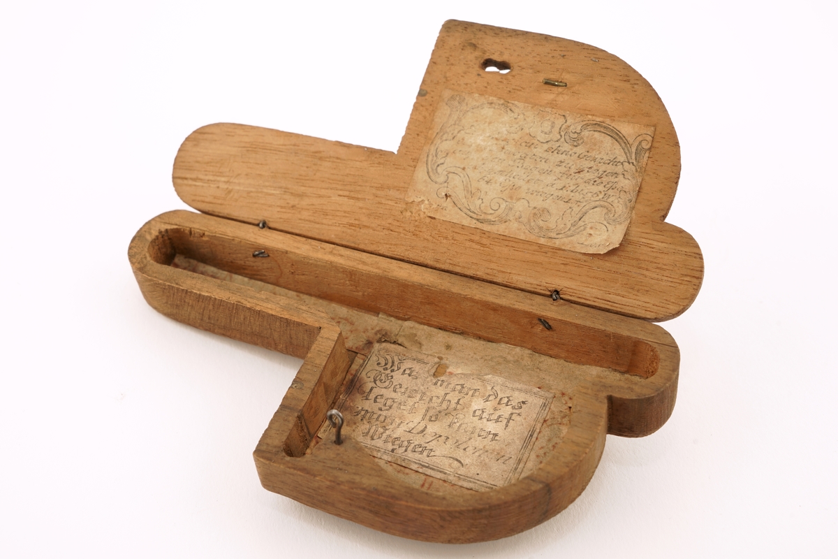 1 tre - eske inneholdende 6 stk. lodd. På oversiden av esken finnes et utydelig merke.
Esken er P - formet.