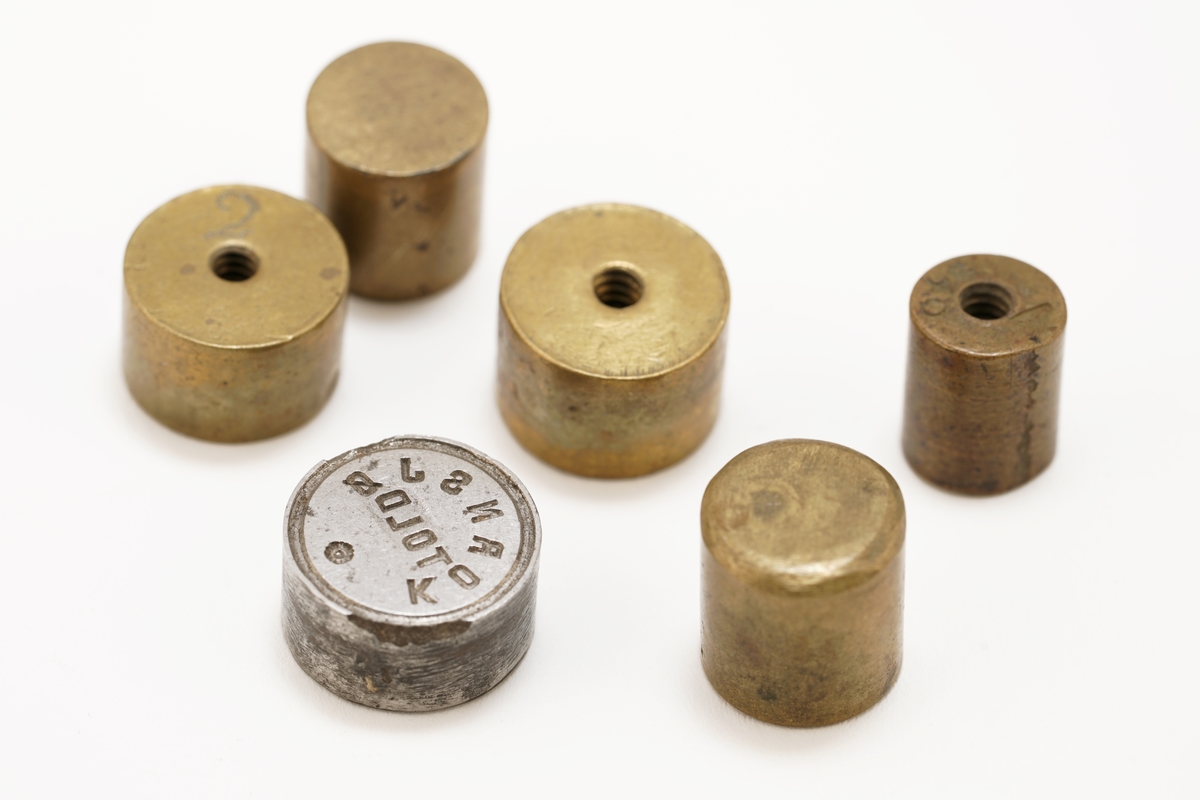 1 tre - eske inneholdende 6 stk. lodd. På oversiden av esken finnes et utydelig merke.
Esken er P - formet.