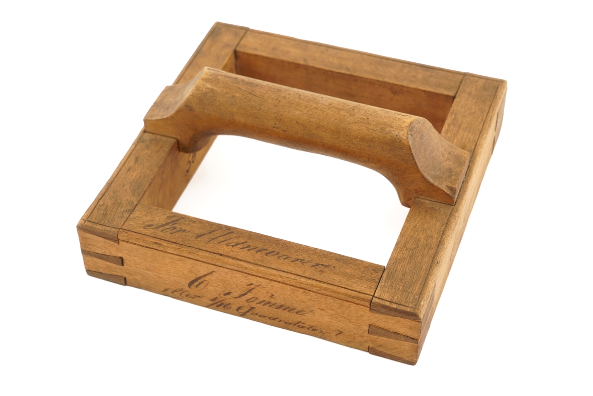 Ramme av tre med håndtak.Til utklipping av over - eller undervektige ull - eller bomulls-
varer.
Utydelig skrift rundt rammen.