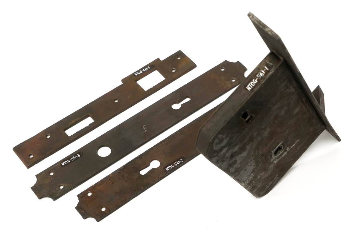 Dørlås for innmontering i dør av jern. Det medfølger tre monteringsbraketter, som selve låsen har vært montert på. Låskassen er rektangulær, med avrundede hjørner på den ene siden, og et større, flatt jern på den motsatte siden.Nøkkel følger med