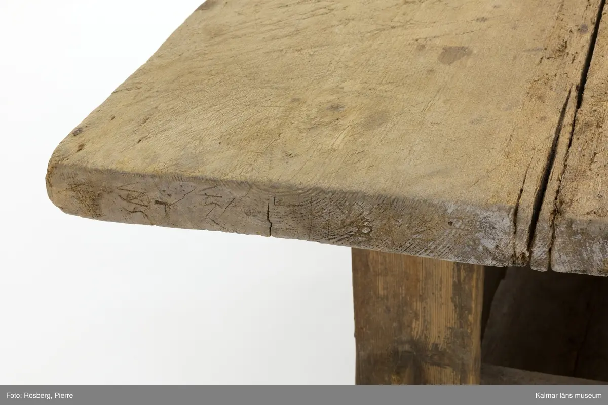 KLM 11169. Bord, långbord. Av furu. Avlångt bord med två ben på vardera kortsida samt lös bordsskiva med rektangulär form. Undertill en avlång låda som håller samman benen. Omålat. Väl använt.