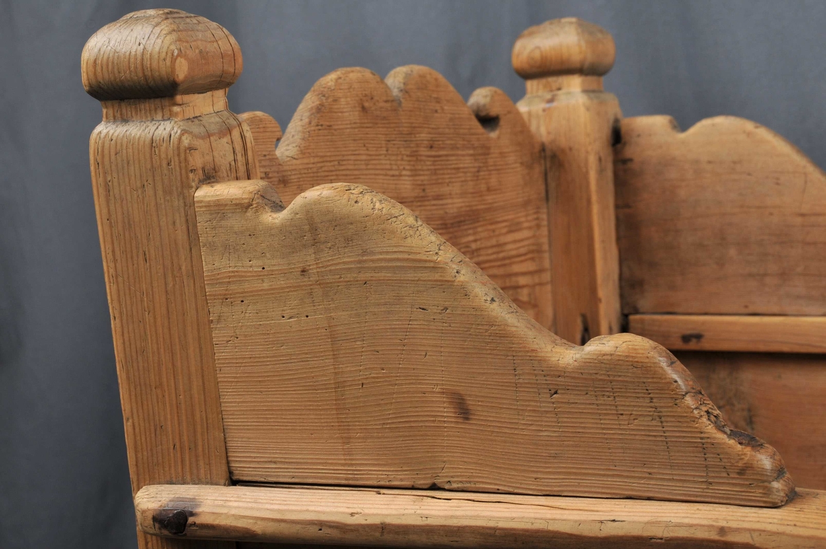 Vogge med nedslitne meiar. Botn er sett saman av 3 bord som ligg lause. Toppen av endeveggane, samt sidekantane er utskorne i bogeformer. Stolpane er firkanta med enkle, utskorne kuler på toppen. Vogga er noko slarkete og slitt.